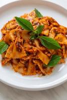 Farfalle pasta with basil and garlic in tomato sauce - Italian sauce photo