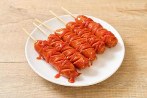 Fried sausage skewer with ketchup on a white plate photo