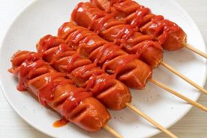 Fried sausage skewer with ketchup on a white plate photo