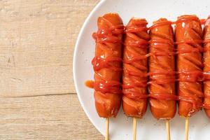 Brocheta de salchicha frita con salsa de tomate en una placa blanca. foto