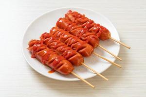 Fried sausage skewer with ketchup on a white plate photo