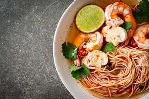 Noodles with spicy soup and shrimps or Tom Yum Kung - Asian food style photo