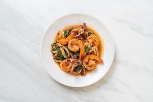 mariscos salteados de camarones y calamares con albahaca tailandesa - estilo de comida asiática foto