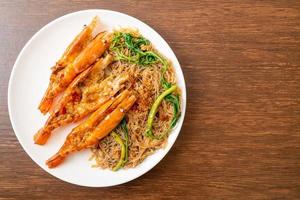 Stir-fried rice vermicelli and water mimosa with river prawns photo