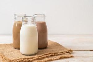 Collection of beverage chocolate milk, coffee and fresh milk in bottle on wood background