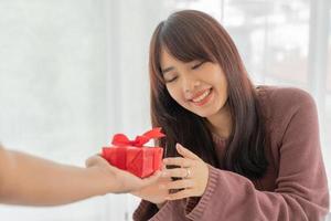 mujer asiática feliz de recibir una caja de regalo o presente foto