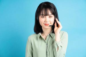 Beautiful Asian female customer care worker wearing headphones photo