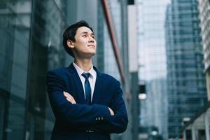 Young Asian businessman with modern building background photo