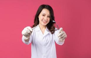 Young Asian female doctor with cheerful expression on background photo