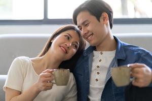 Young Asian couple hugging happily at home photo