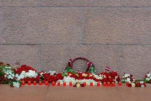 Latvia 100 years. Red and white flowers compositions at the Freedom Monument in city Riga, Latvia photo