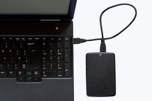 A portable computer and a USB drive on a white background. photo