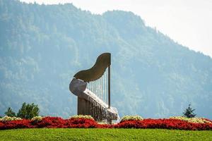 la fuente del arpa en ossiach, austria. bosque y montañas al fondo. foto