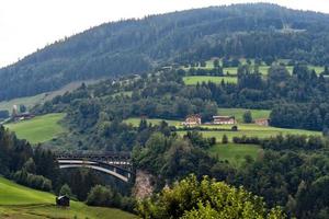 un pintoresco paisaje alpino con un antiguo puente ferroviario. Austria. foto