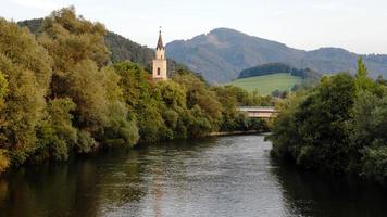Vista del río Mur con iglesia en Leoben, Austria foto