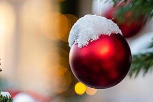 adornos de colores en las ramas de los árboles de navidad cubiertos de nieve foto