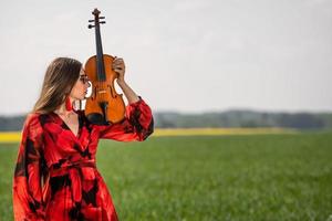 retrato de una mujer joven positiva. parte de la cara está cubierta por el cuello del violín - imagen foto