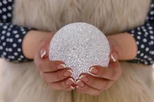 Woman's hands with a glittering Christmas decoration photo