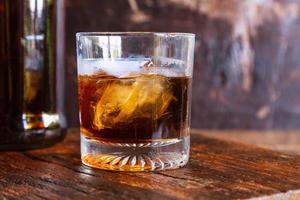 Liquor glass and decanter on wooden table photo