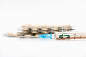 Medical syringe and pills isolated on white background photo