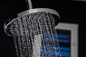 Close up of Water flowing from shower in the bathroom photo