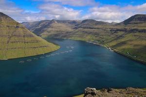 Camine por la montaña klakkur con un gran paisaje de fiordos panorámicos y pintorescos sobre las islas feroe foto