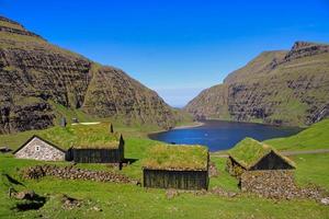 El histórico pueblo de Saksun en las Islas Feroe en un gran día con cielo azul en verano foto