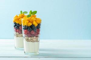 Homemade mango, raspberry, and blueberry with yogurt and granola - healthy food style photo