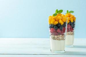 Homemade mango, raspberry, and blueberry with yogurt and granola - healthy food style photo