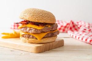 hamburguesa de cerdo o hamburguesa de cerdo con queso, tocino y papas fritas foto