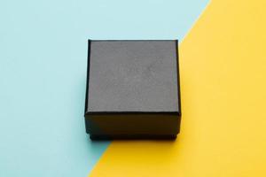 Black box packaging on half blue and yellow background photo