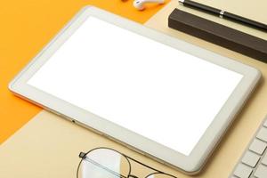 tableta con maqueta de pantalla en blanco en la mesa de trabajo foto