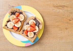Whole wheat bread toasted with fresh banana, strawberry, and chocolate for breakfast