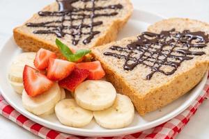 pan integral tostado con plátano fresco, fresa y chocolate para el desayuno foto