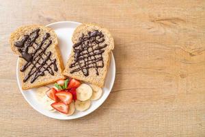 Whole wheat bread toasted with fresh banana, strawberry, and chocolate for breakfast photo