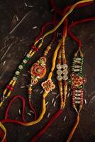 Raksha Bandhan background with an elegant Rakhi and scattered rice. A traditional Indian wrist band which is a symbol of love between Brothers and Sisters. photo
