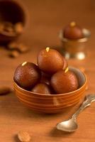 Gulab Jamun in bowl and copper antique bowl with spoon. Indian Dessert or Sweet Dish. photo