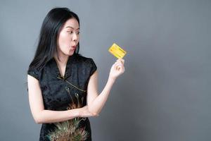 Asian woman wear Chinese traditional dress with hand holding credit card photo