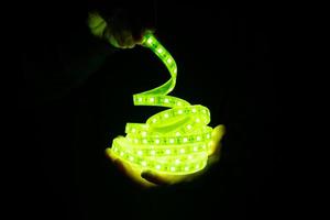 iluminación de tira de led verde en la mano