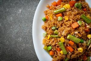 Fried rice with green peas, carrots, and corn - vegetarian and healthy food style photo