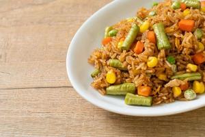 Fried rice with green peas, carrots, and corn - vegetarian and healthy food style photo