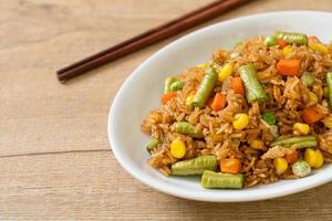 arroz frito con guisantes, zanahorias y maíz - estilo de comida vegetariana y saludable foto