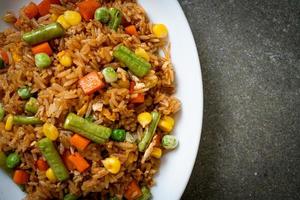 Fried rice with green peas, carrots, and corn - vegetarian and healthy food style photo