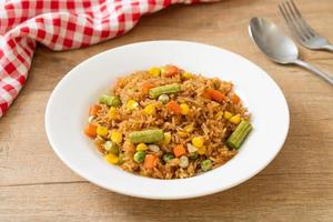 Fried rice with green peas, carrots, and corn - vegetarian and healthy food style photo