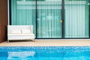 Empty outdoor patio chair near swimming pool photo