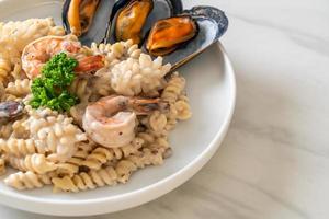 Spiral pasta mushroom cream sauce with seafood - Italian food style photo