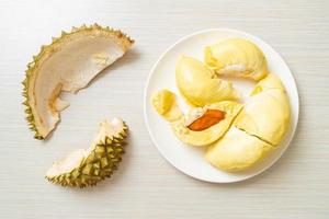 Durian maduro y fresco, cáscara de durian en la placa blanca. foto