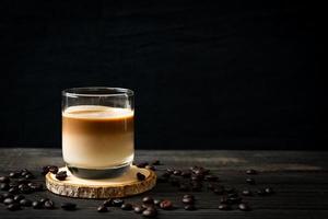 Glass of latte coffee, coffee with milk on wood background photo