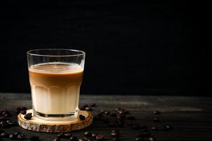 Glass of latte coffee, coffee with milk on wood background photo