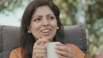 Woman having conversation with other woman whilst drinking video